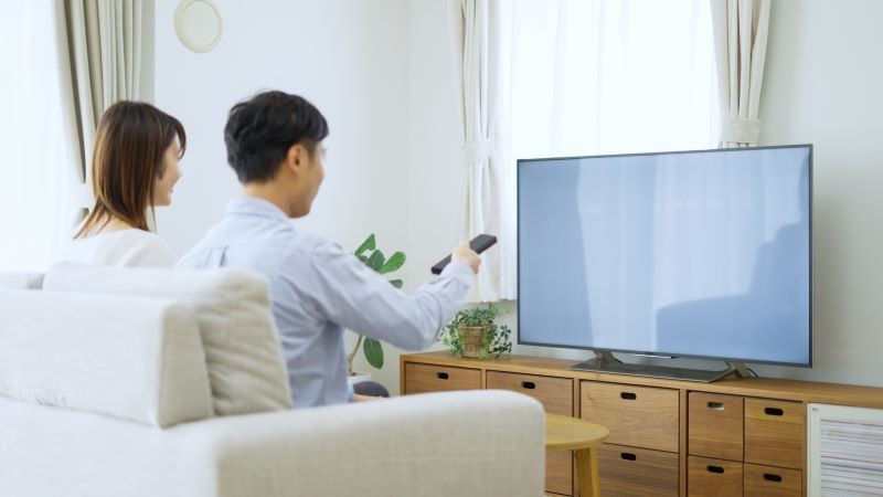 自宅でテレビを見る夫婦